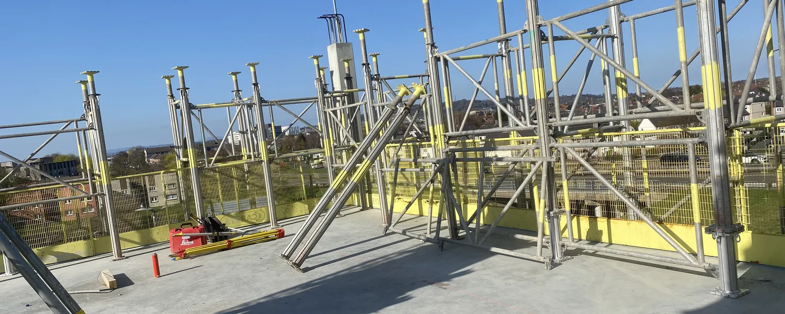 Table formwork and props set out on a deck under a clear blue sky
