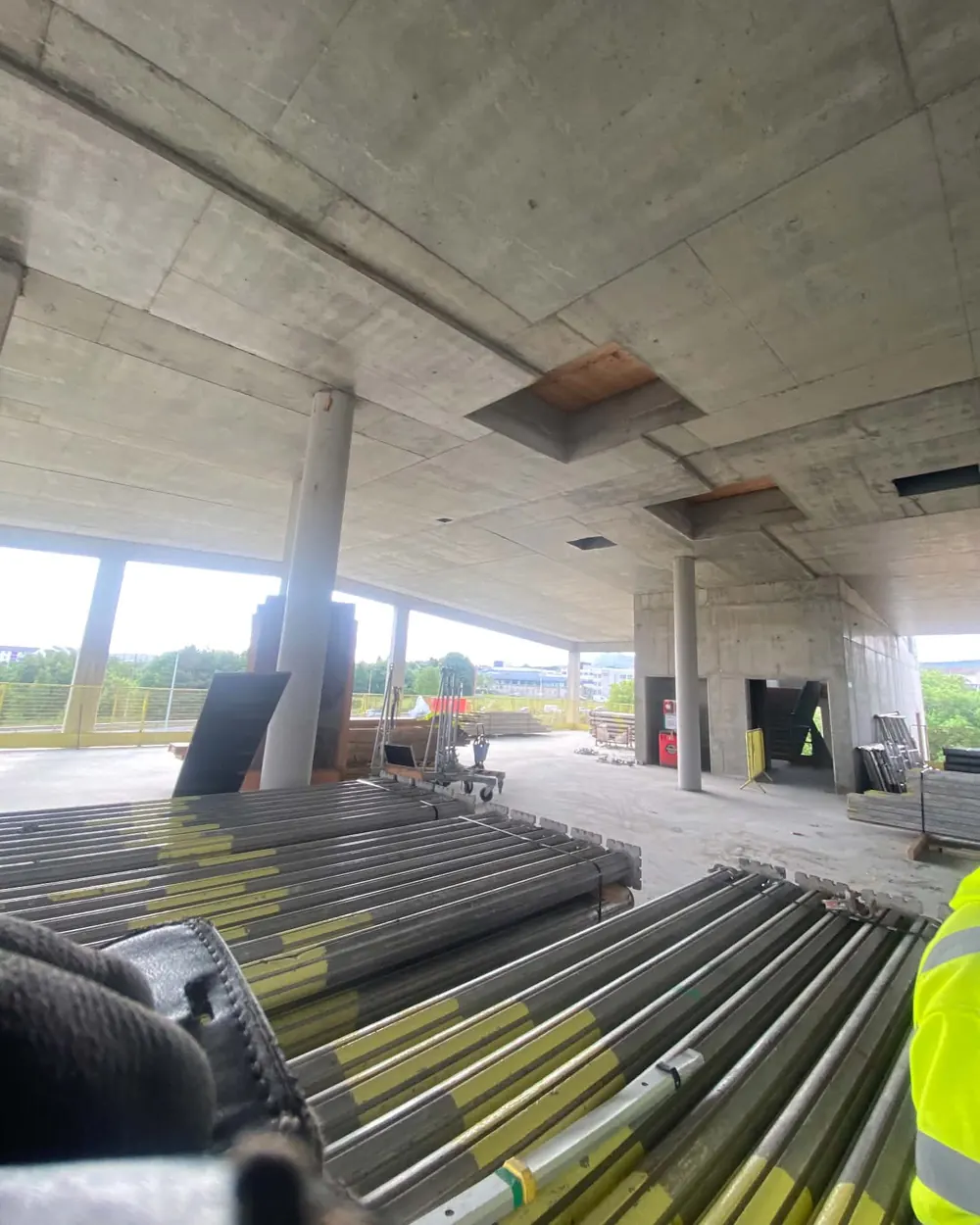 Robert's view across a finished concrete floor, hi-vis sleeve in shot