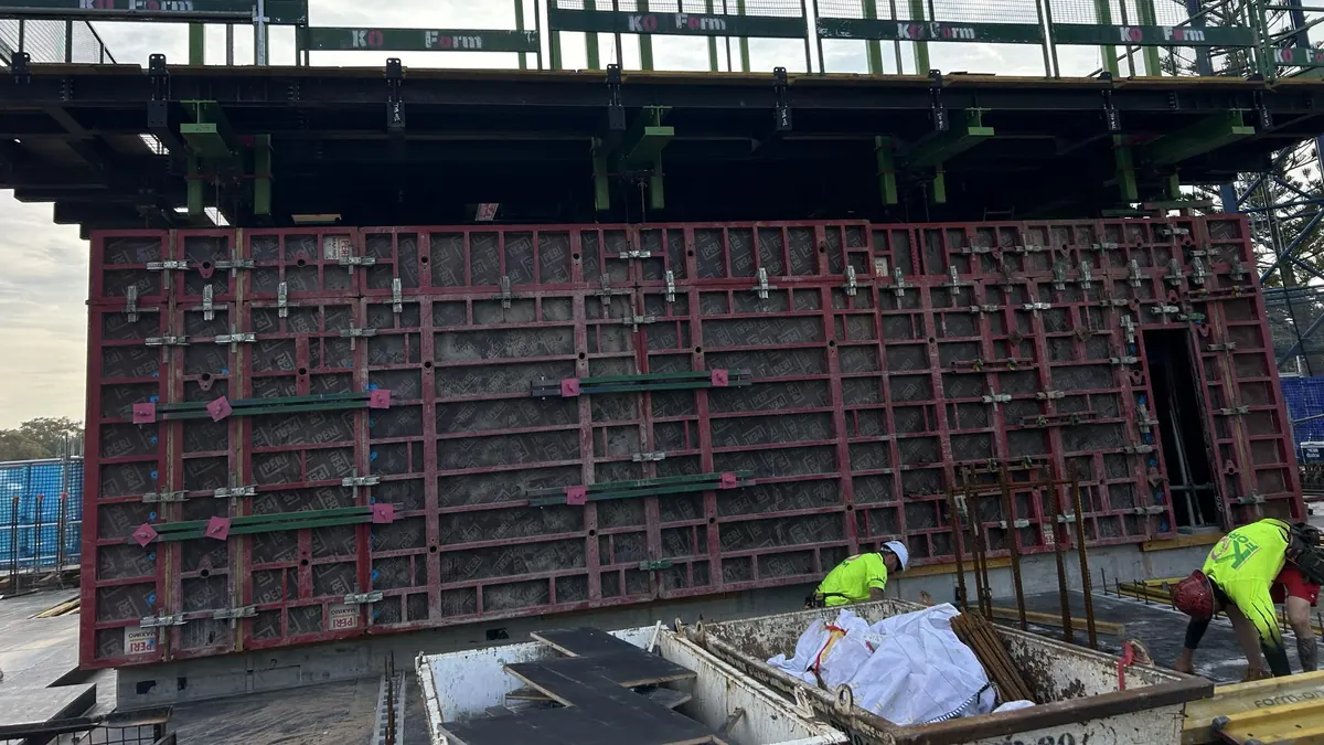 Crew in hi-vis working at a large wall formwork panel on an Australian site