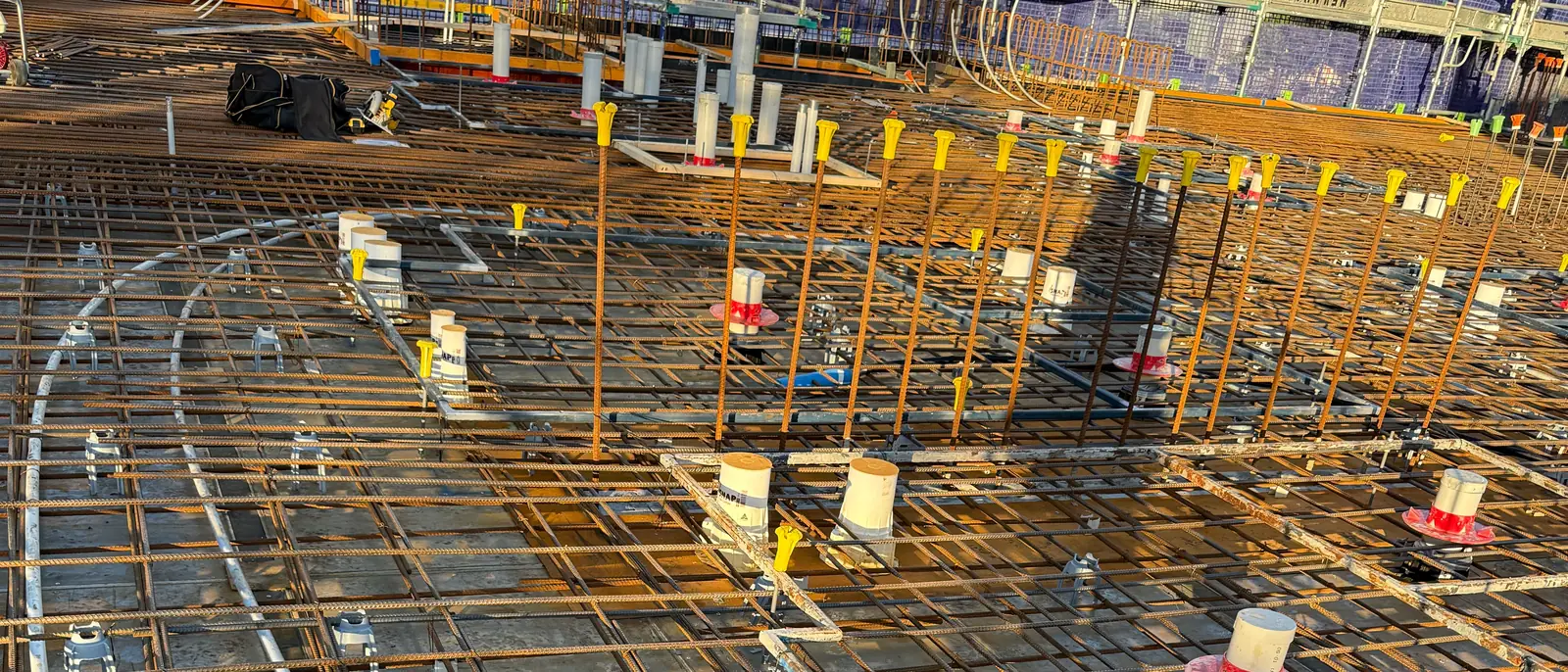 Rebar deck with cast-in sleeves at golden hour, ready for the pour