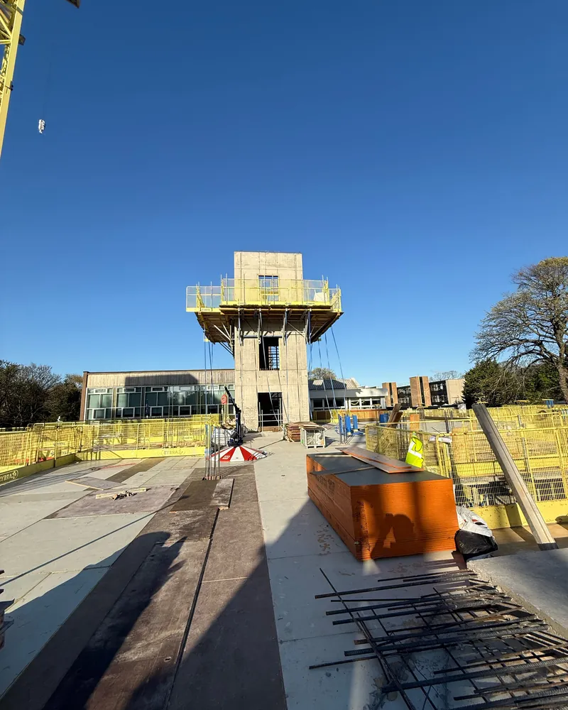 Concrete core with a yellow climbing platform against a blue sky, on one of Robert's sites